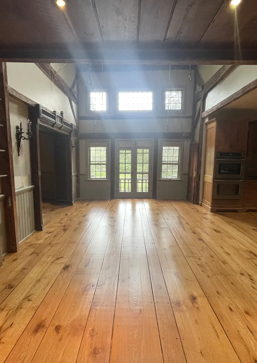 Wide plank pine floor in a timber frame great room with French doors
